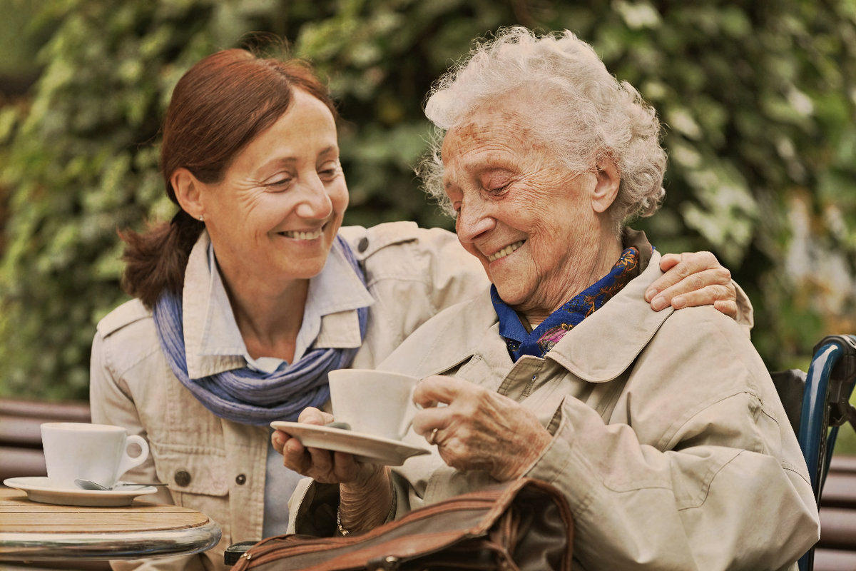 middle aged woman drinking tea with an elderly woman